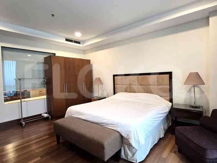 Bedroom with a bed, bench, wardrobe, and lamps.