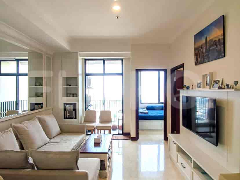 Bright living room with a cream sofa, a TV, and a view.