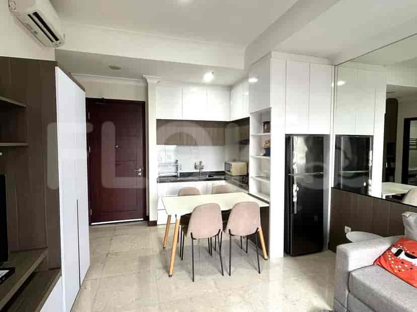 A compact kitchen with white cabinetry, a small dining table, and a modern design.