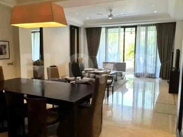 A living room with a dining table, a fan, and curtains.