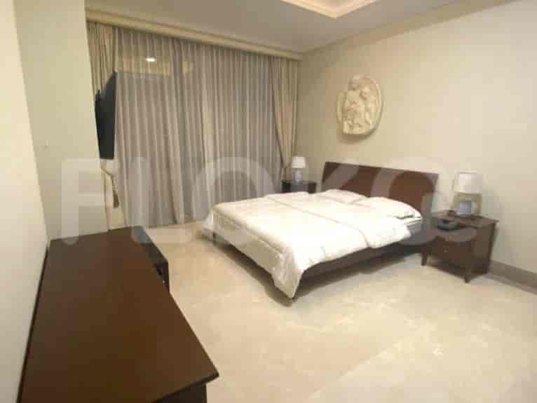 A bedroom featuring a large bed, nightstands, and a wall-mounted TV.