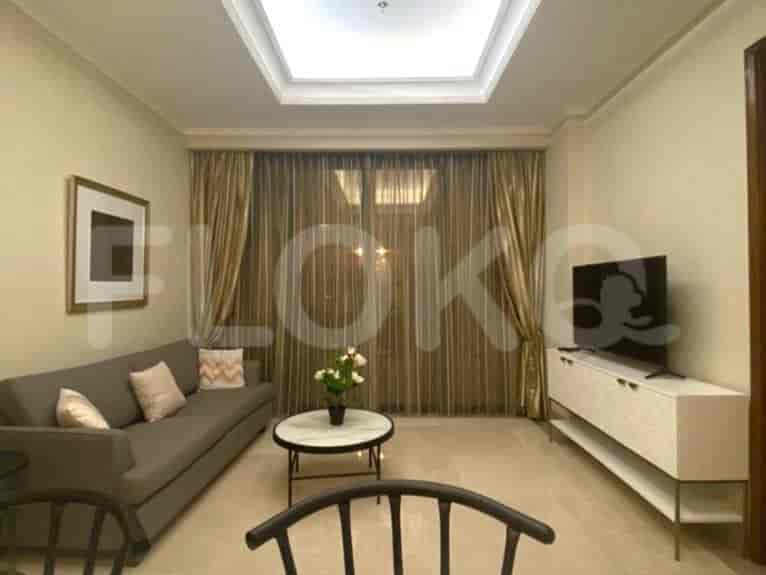 Modern living room with a grey sofa, TV, and a round coffee table.