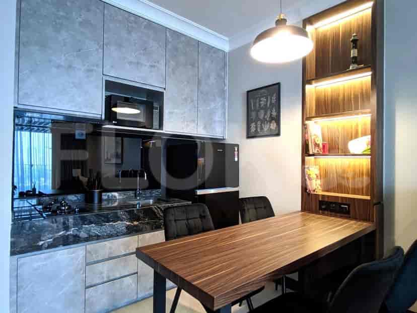 A modern kitchen with wooden table and black cabinets.