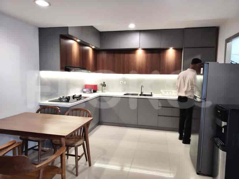Modern kitchen with dark cabinetry and a dining table.