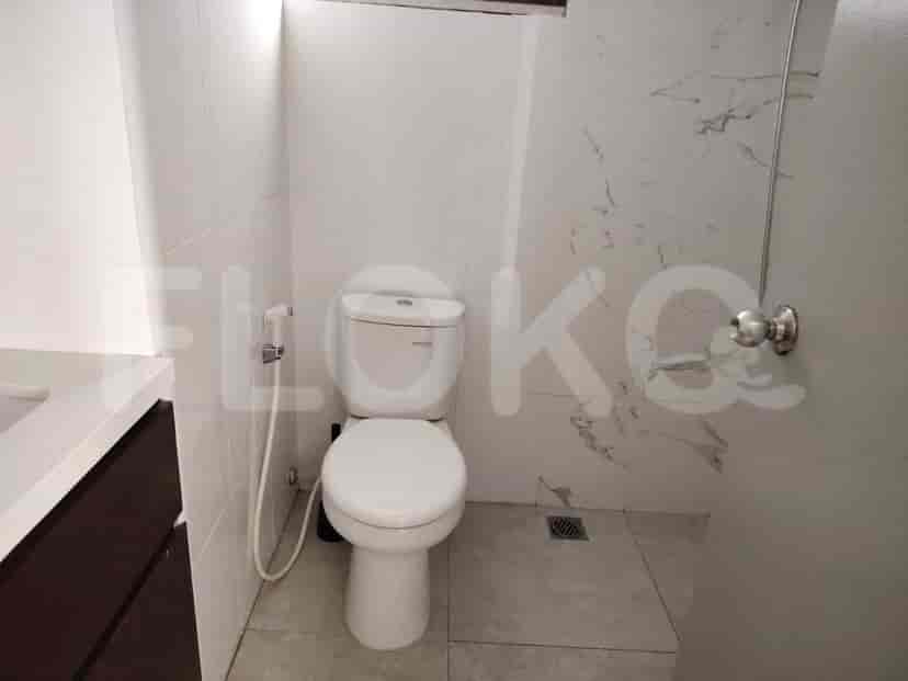 Bathroom with a toilet and marble walls.