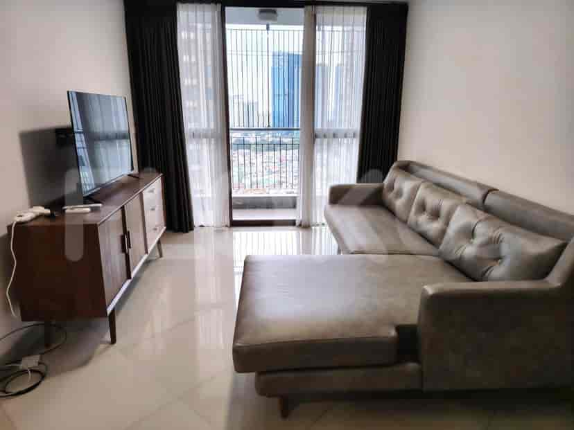 Living room with grey L-shaped sofa, TV, and city view.
