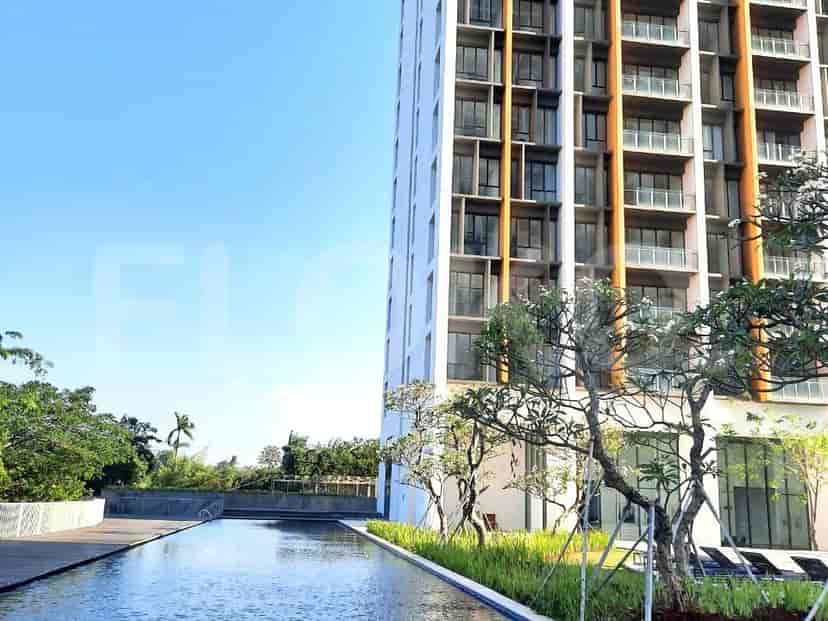 Eksterior bangunan modern dengan kolam renang dan area hijau.