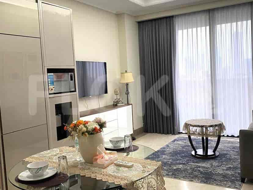 An open-plan space with a dining table, a smart TV, and a microwave.