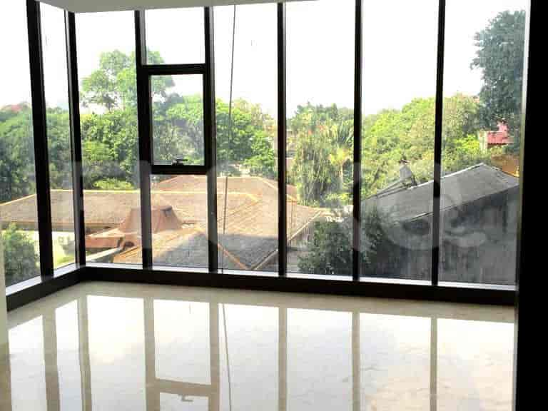 A room with a large window and a view of trees.
