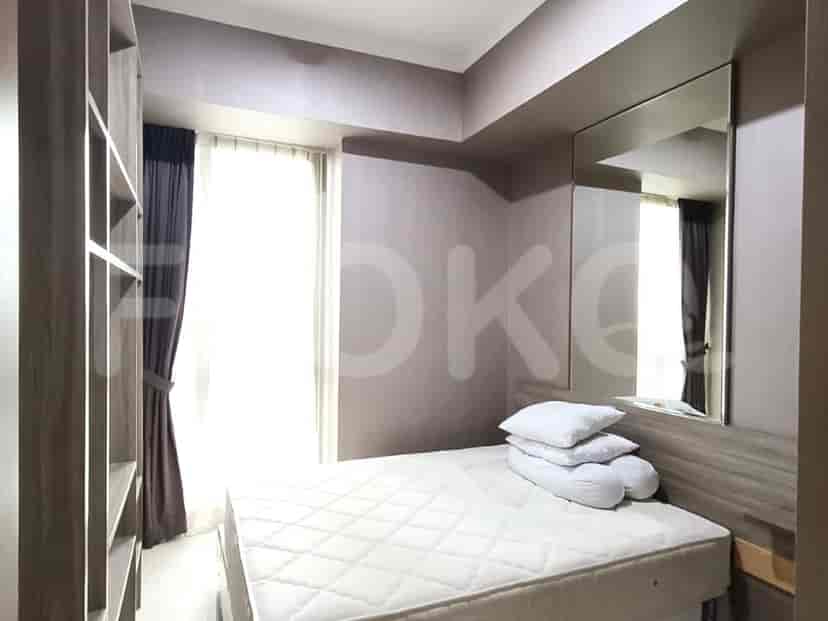 A cozy bedroom with a bed, mirror and window.