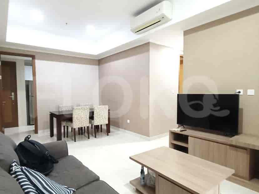 A living room with a dining area, sofa, and TV.