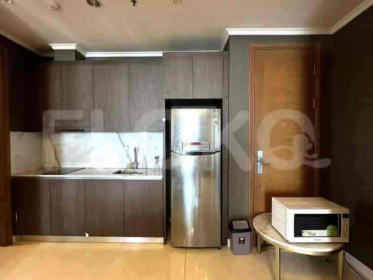 A compact kitchen with built-in cabinets and stainless steel appliances.
