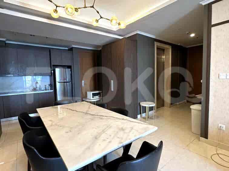 A dining area with a marble table and kitchen with stainless steel appliances.