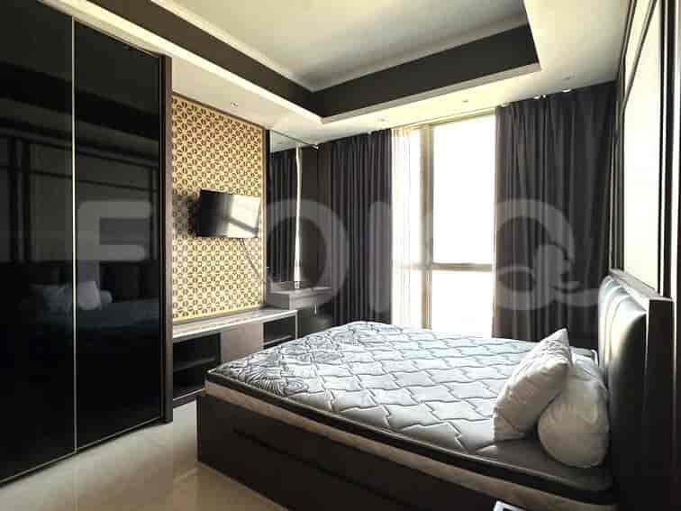 A modern bedroom with a large bed and a wall-mounted TV.