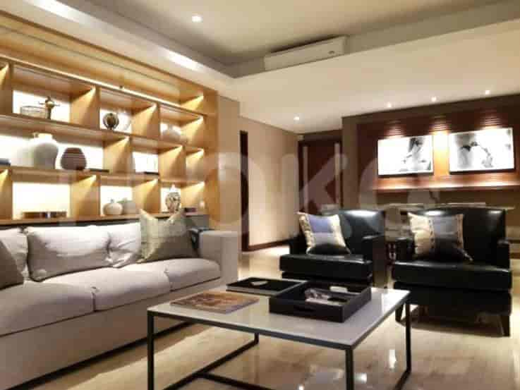 A well-lit living room featuring a sofa, two black armchairs, and a coffee table.
