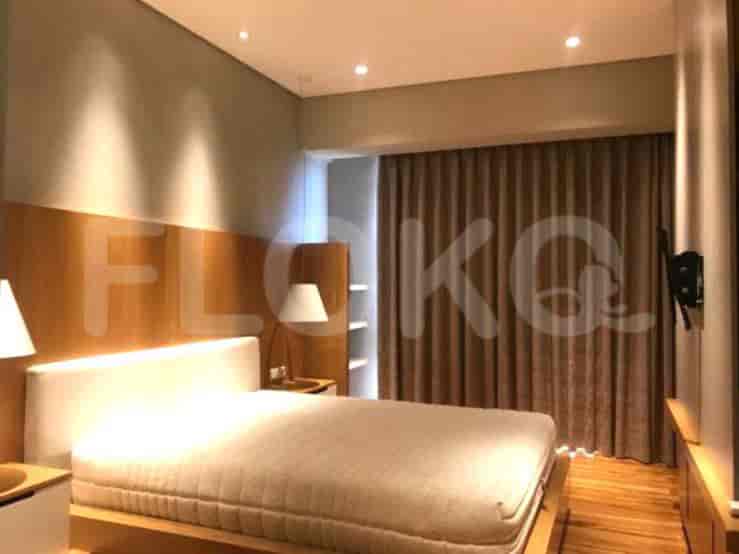 A bedroom with a bed, bedside tables, and curtains.