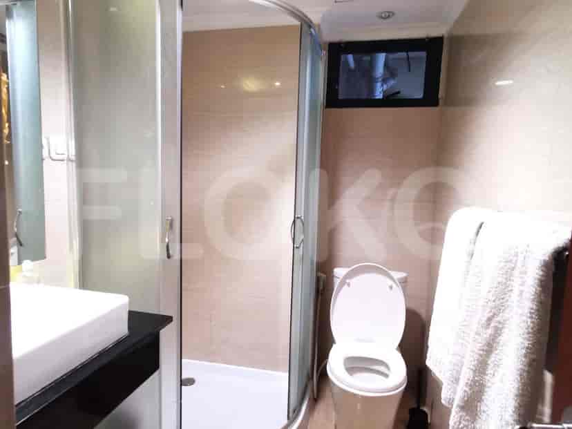 A modern bathroom with a glass shower enclosure, a toilet, and a sink.