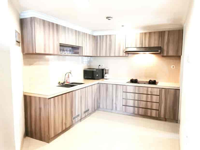 A modern kitchen featuring wooden cabinets, a stove, and a microwave.