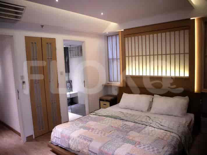 Bedroom featuring a bed, sliding doors, and a window with wooden details.