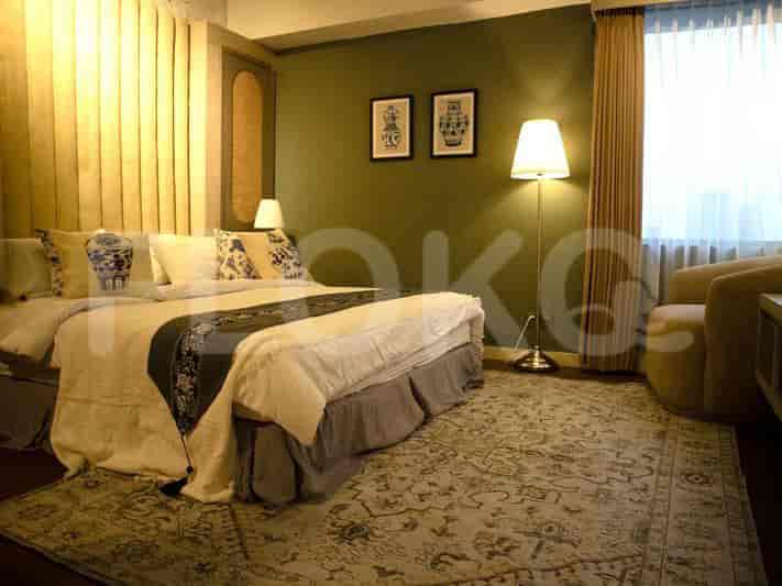 Kamar tidur mewah dengan tempat tidur berukuran king, karpet bermotif, dan dekorasi bergaya.