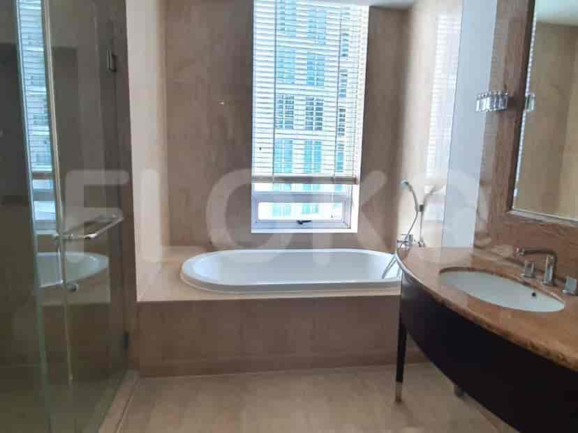Kamar mandi yang menampilkan bak mandi, wastafel dengan cermin, dan area pancuran.