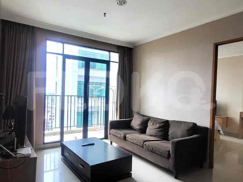 A living room with a brown sofa, coffee table, and large windows.