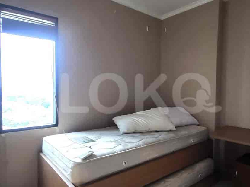 A small bedroom with a bed and a window.