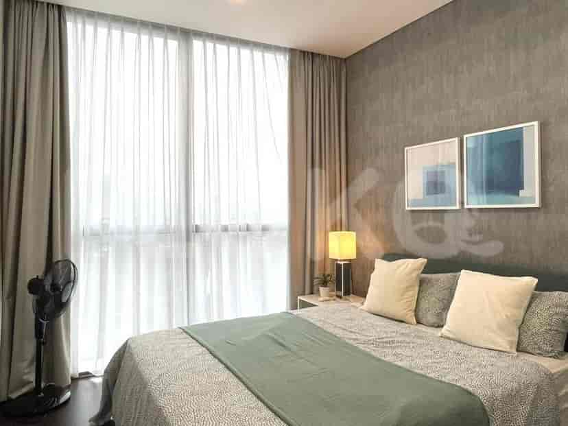 A master bedroom with a grey bed, curtains and two paintings.