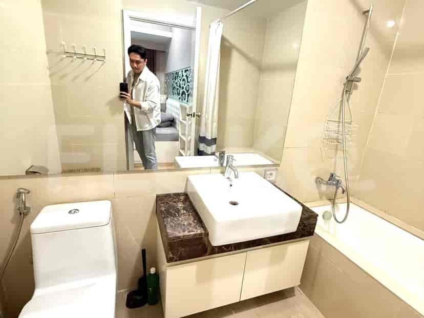 A bathroom with a sink, toilet, and mirror.