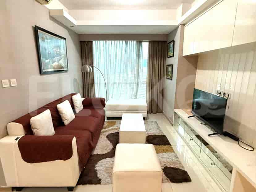 A living room with a sofa, TV, and window.