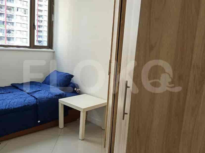 Small bedroom with a single bed, white side table, and blue bedding.