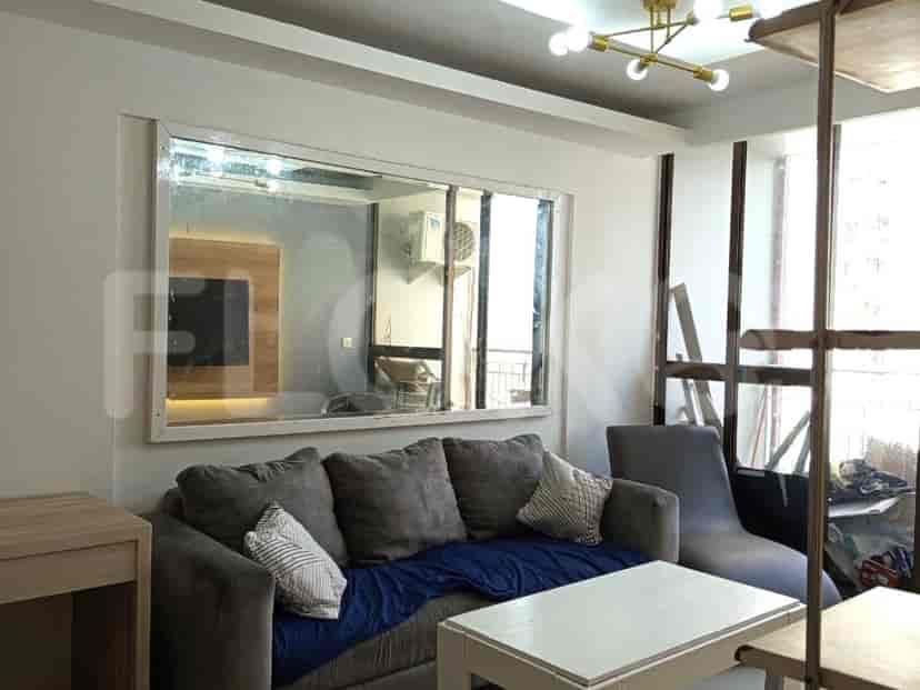 Living room featuring a grey sofa, white coffee table, and large mirror.