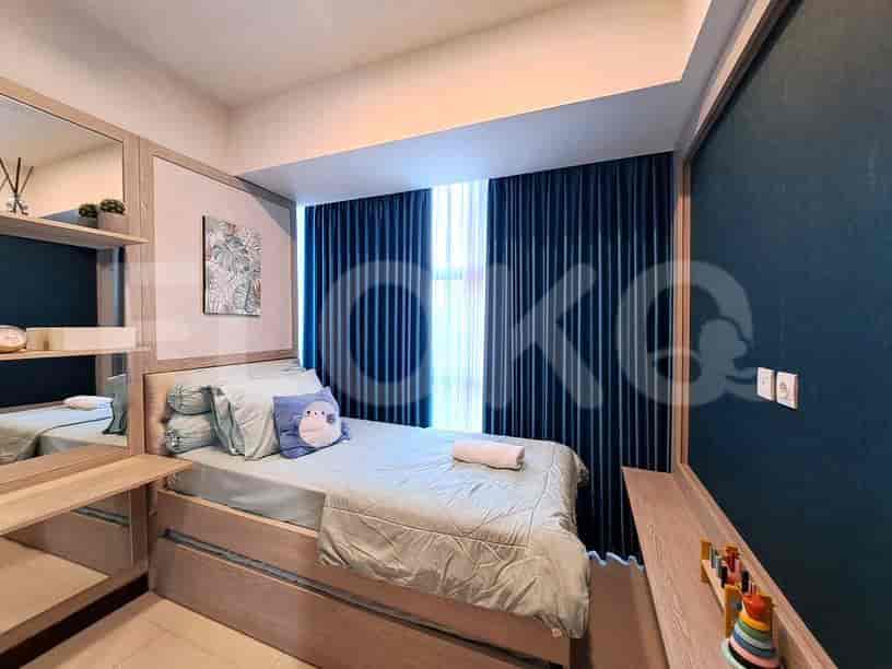 A cozy bedroom with a bed, mirror, and curtains.