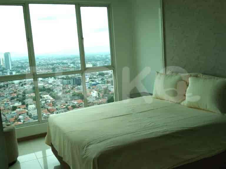 Bedroom with a large window overlooking the city and a bed.