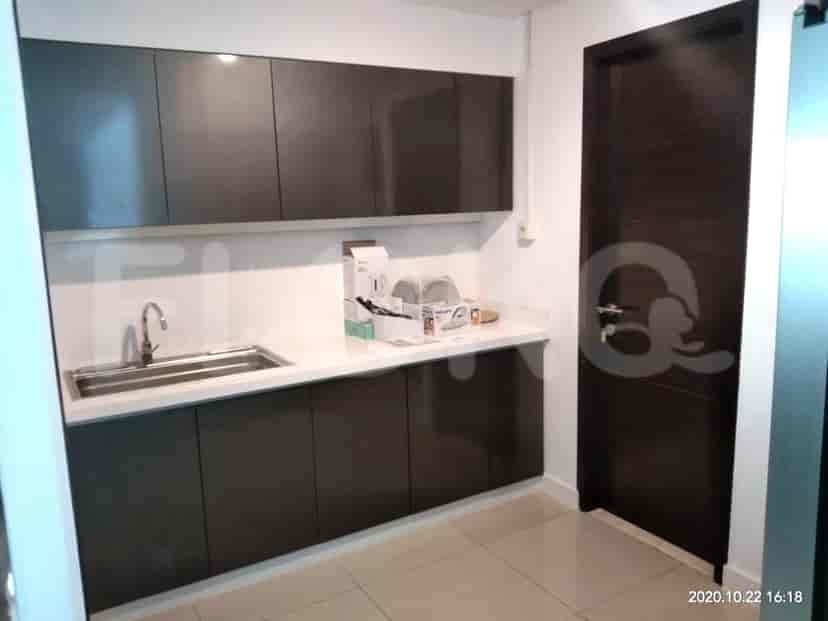 A modern kitchen with grey cabinets and a stainless steel sink.