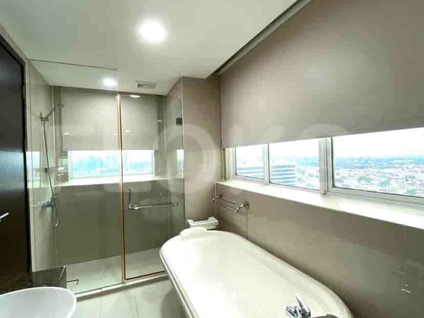 Luxurious bathroom with a bathtub, shower, and large windows.
