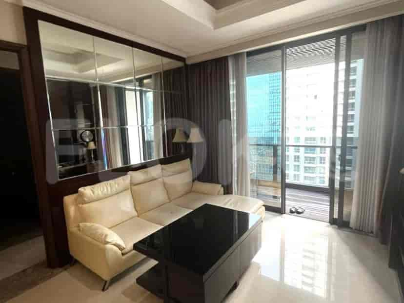 Living room with a cream-colored sofa, mirrored wall, and balcony access.