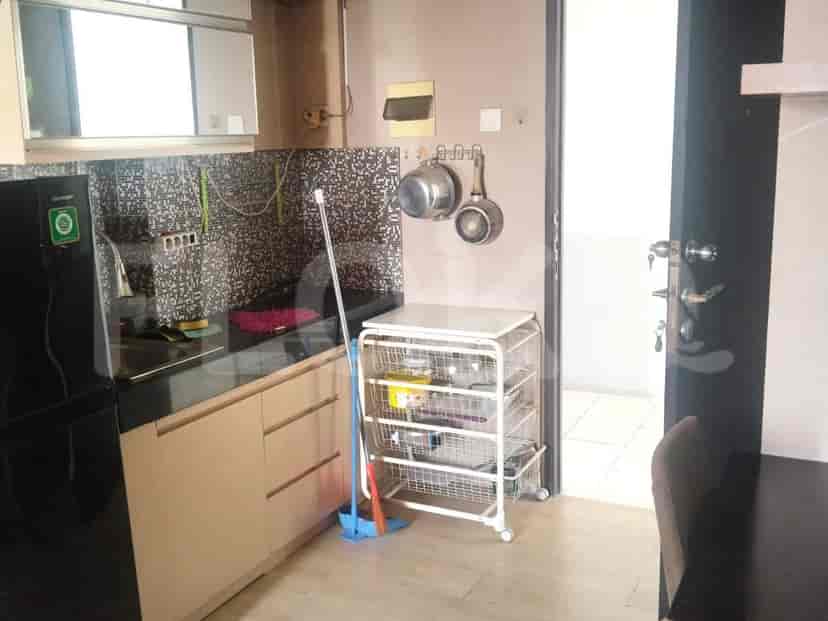 Dapur dengan lemari, kompor, dan panci gantung.