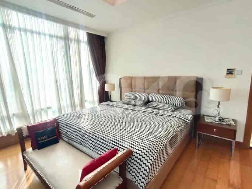 Bedroom with a king bed and large windows.