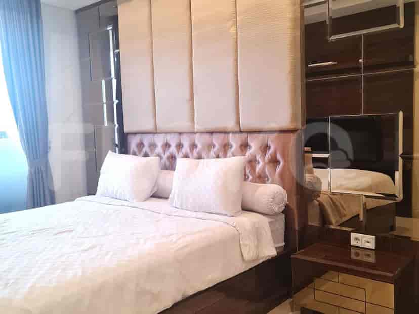 Bedroom with a bed, mirrors, and nightstands.