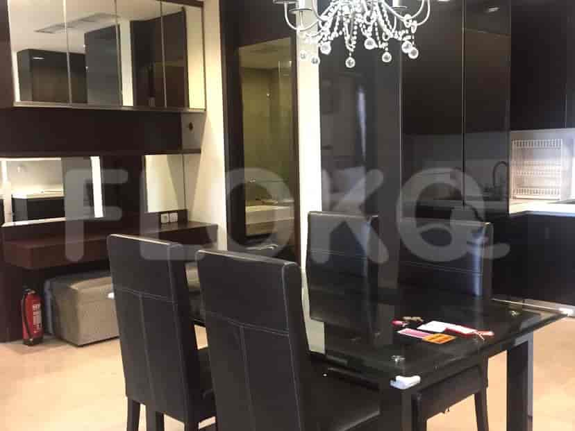 Dining area with table and chairs, kitchen in the background.