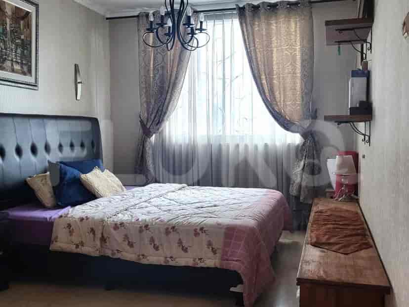 A bedroom with a bed, curtains, and a chandelier.