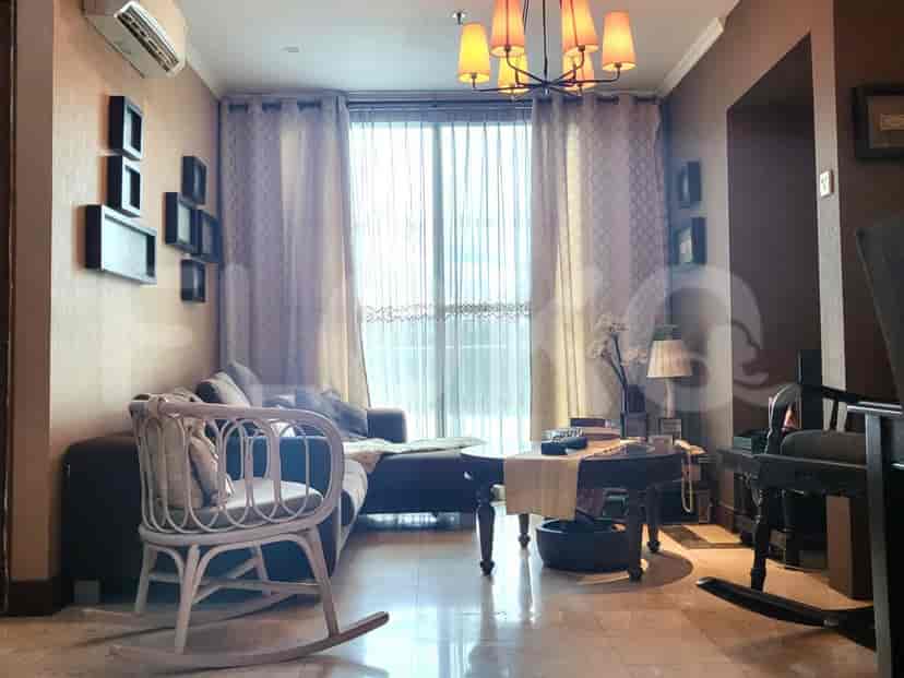 A living room with a sofa, rocking chair, and a chandelier.