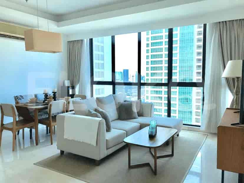Living room with an L-shaped sofa and city views through expansive windows.