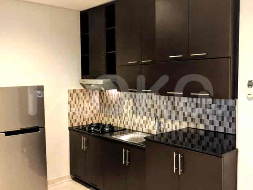 A modern kitchen with dark cabinets and stainless steel appliances.