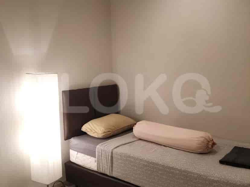 A minimalist bedroom with a bed and a floor lamp.