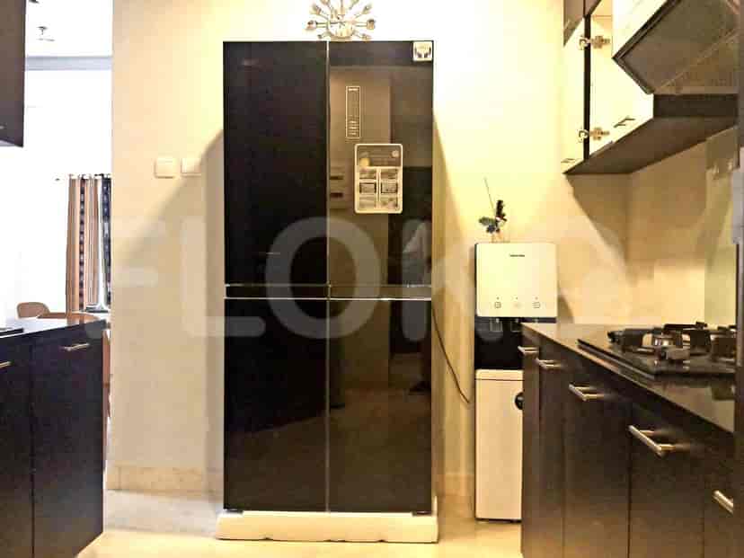 A modern kitchen with a refrigerator and cabinets.