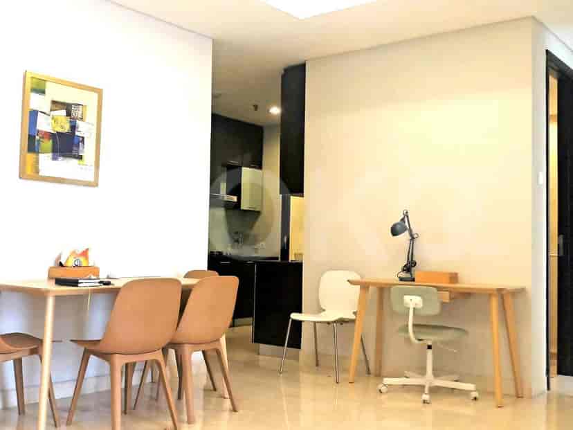 A dining area with a table and chairs next to a work desk.
