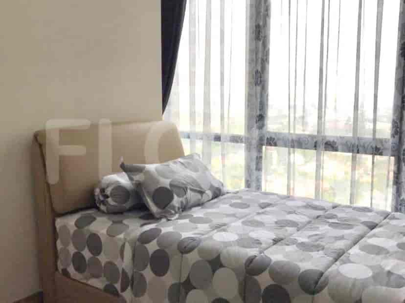A bedroom with a bed and sheer curtains.