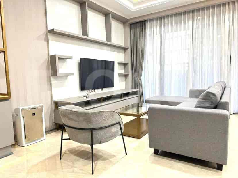 Spacious living room with an L-shaped sofa, smart TV, and large windows.